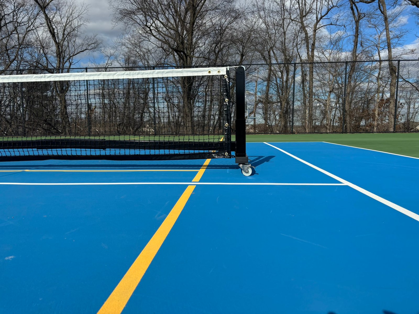 Pro Heavy Duty Portable Pickleball Net | Optional Wheels 5 Side view showing raised steel frame allowing pickleballs to roll underneath the net system.